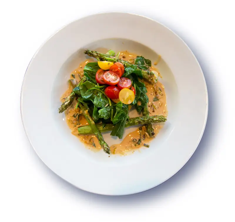 Plate of Asparagus with sauce and tomatoes
